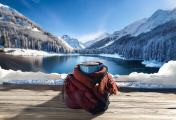 Sticker - A cozy mug sits on a wooden table overlooking a frozen lake with snow-capped mountains in the background.