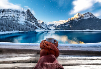 Poster - A hand in warm gloves holds a steaming mug against a backdrop of snow-capped mountains reflecting in a pristine lake.