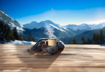 Poster - A steaming mug of coffee sits on a wooden table with a cozy scarf, overlooking a snowy mountain range.