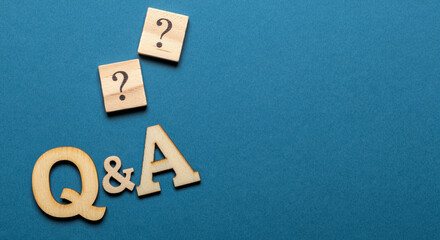 Poster - Wooden question marks and letters Q&A graphic with blue background for marketing communication