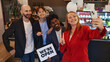 © master1305 - Diverse group of colleagues taking selfie together, holding we are open sign to celebrate launch of new business. Opening coffee shop, cafe. Concept of business, achievement, success, entrepreneurship