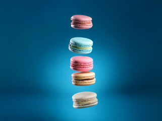 Aufkleber - Three colorful macarons, stacked in the air, against a blue background.