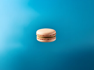 Aufkleber - A single macaron with green filling is floating against a blue background.
