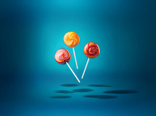 Aufkleber - Three colorful lollipops with swirling patterns on a blue background.
