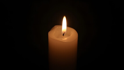 Poster - Candle light shines bright on a dark black surface effectively creating ambiance.