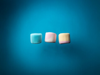 Aufkleber - Three colorful marshmallows levitate against a blue background.