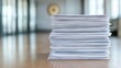 © CreativeLoom - Stack of white papers on a wooden table, representing organization and productivity in an office setting.