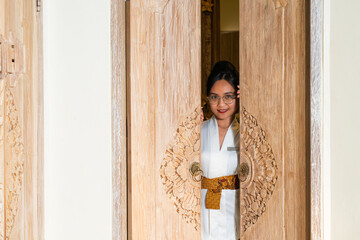 Woman Peeking Through Carved Wooden Door