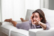 © Giulio_Fornasar - Woman lying on couch pointing finger and making funny face