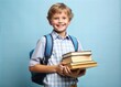 © Aminograpix - Happy schoolboy with backpack and textbook on stack of books against light blue background. Back to school
