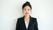 © yarku20 - A confident young woman wearing a professional business suit, smiling warmly and exuding professionalism and approachability against a clean, neutral background, perfect for personal branding