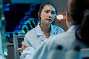 Wall Mural - two female scientists wearing lab coats having a discussion about research in a laboratory setting