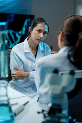 Wall Mural - two female scientists are discussing research results in a laboratory, with one scientist looking co