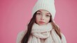© tapong117 - Young girl wearing cozy winter knitwear, posing in front of a pink background for a stylish winter fashion concept