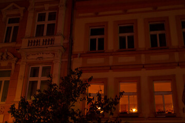 A tall building, featuring an abundance of windows, is beautifully lit up, casting a glow throughout the city at night