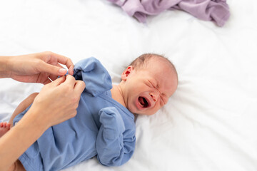 Canvas Print - Mom change her son clothes on bed