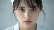 © chic designs - 柔らかな光の中で鋭い視線を向ける若い看護師のポートレート