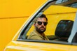 © Vii - A person with a beard and sunglasses relaxing in a bright yellow vehicle