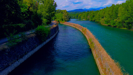 Wall Mural - Trezzo sul Adda, Italy. Aerial view of a mountain freshwater river with low water level surrounded by green trees. White swans on the river. Forest. Hydroelectric power station. Green planet. Ecology