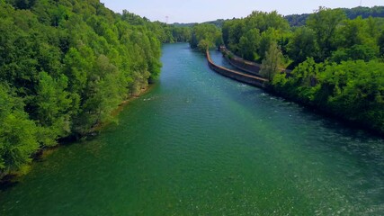 Wall Mural - Trezzo sul Adda, Italy. Aerial view of a mountain freshwater river with low water level surrounded by green trees. White swans on the river. Forest. Hydroelectric power station. Green planet. Ecology