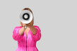 © Pixel-Shot - Mature woman with megaphone on grey background
