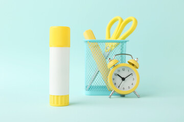 Canvas Print - Glue stick, alarm clock, holder and scissors on turquoise background