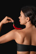 © Pixel-Shot - Sexy young woman with chili pepper on black background