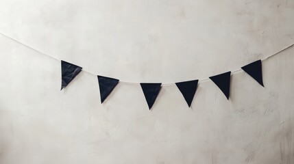Poster - A Halloween banner with simple geometric black shapes on a white string, hanging against a plain wall for a subtle festive touch