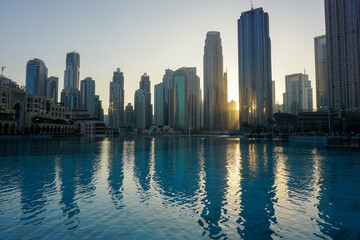 Dubai's modern city skyscraper skyline at sunset - business center of United Arab Emirates reflecting in the water