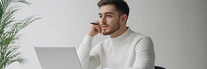 Leinwandbilder - The young freelancer is deeply engaged while working on his laptop, surrounded by a clean and minimalist backdrop that enhances productivity. Generative AI