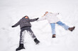 © Ксения Левашова - Joyful Winter Fun Making Snow Angels Together with Family and Friends in the Snowy Landscape