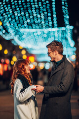 Wall Mural - Loving festive couple dancing on street and celebrating new year.