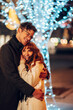 © Zamrznuti tonovi - An affectionate couple is embracing on city street at christmas eve.