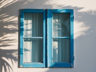 Blue wooden window with palm shadows on white wall.