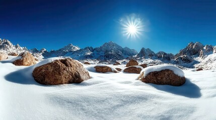 Wall Mural - A panoramic view of snow-blanketed mountains with scattered boulders under the bright sun, capturing the raw beauty of a winter wonderland landscape.