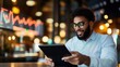 © LifeMedia - A smiling man in glasses uses a tablet to track financial market trends at a cozy, bokeh-lit café while looking energetic and optimistic about investments.