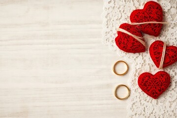 Poster - Red lace hearts and wedding rings on a wooden background.