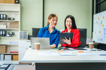 Two young female business consultants work on startup, collaborating on mobile app development social media strategies. whiteboards, documents, they aim to build a successful e-commerce business.