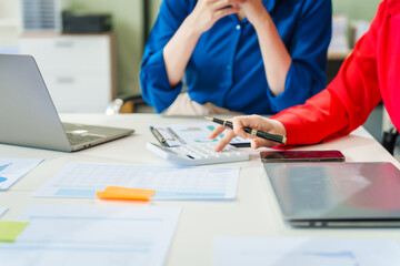 Two young female business consultants work on startup, collaborating on mobile app development social media strategies. whiteboards, documents, they aim to build a successful e-commerce business.