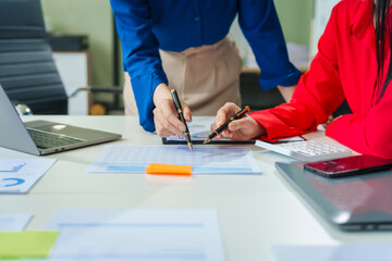 Two young female business consultants work on startup, collaborating on mobile app development social media strategies. whiteboards, documents, they aim to build a successful e-commerce business.