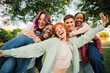 © Jose Calsina - Group of joyful young friends having fun outdoors, embracing and laughing together in a park. Energetic, carefree and multiracial people enjoying a lively and playful moment of friendship