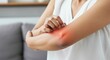 © mariiaplo - Woman Experiencing Elbow Pain in a Casual Setting
