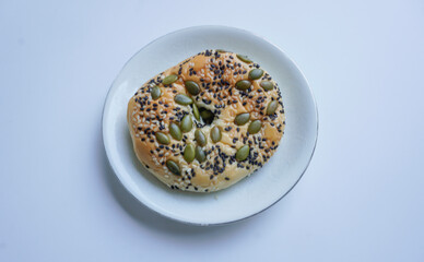 Delicious soft whole grain bread on a white plate on a white background.