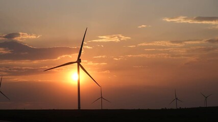 wind turbines at sunset. wind turbines in the orange sky. rural areas with renewable energy sources.