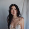 © KerXing - Asian girl in a sundress, posing against a light grey backdrop.