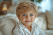 © stanhert - A little boy with blue eyes sitting on a couch