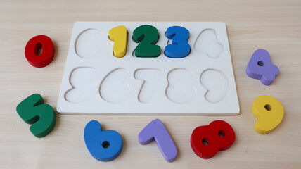 0, 1, 2, 3, 4, 5, 6, 7, 8, 9 numeral alphabet. digits from wooden material, colorful toys for kids. font for logo, Poster. number wooden puzzle