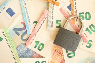 Wall Mural - Euro banknotes with lock on wooden table background