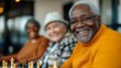 © fotogurmespb - Group of seniors laughing together while playing a lively game of chess at a local community center, embodying the joy of connection in senior life