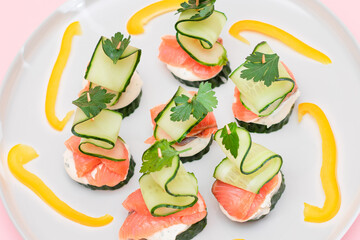 Wall Mural - Canapes without Bread with Fresh Salmon, Cucumber and Cream Cheese on White Plate. Easy Breakfast. Diet Food. Quick and Healthy Sandwiches. Healthy Snacks with Tasty Fillings